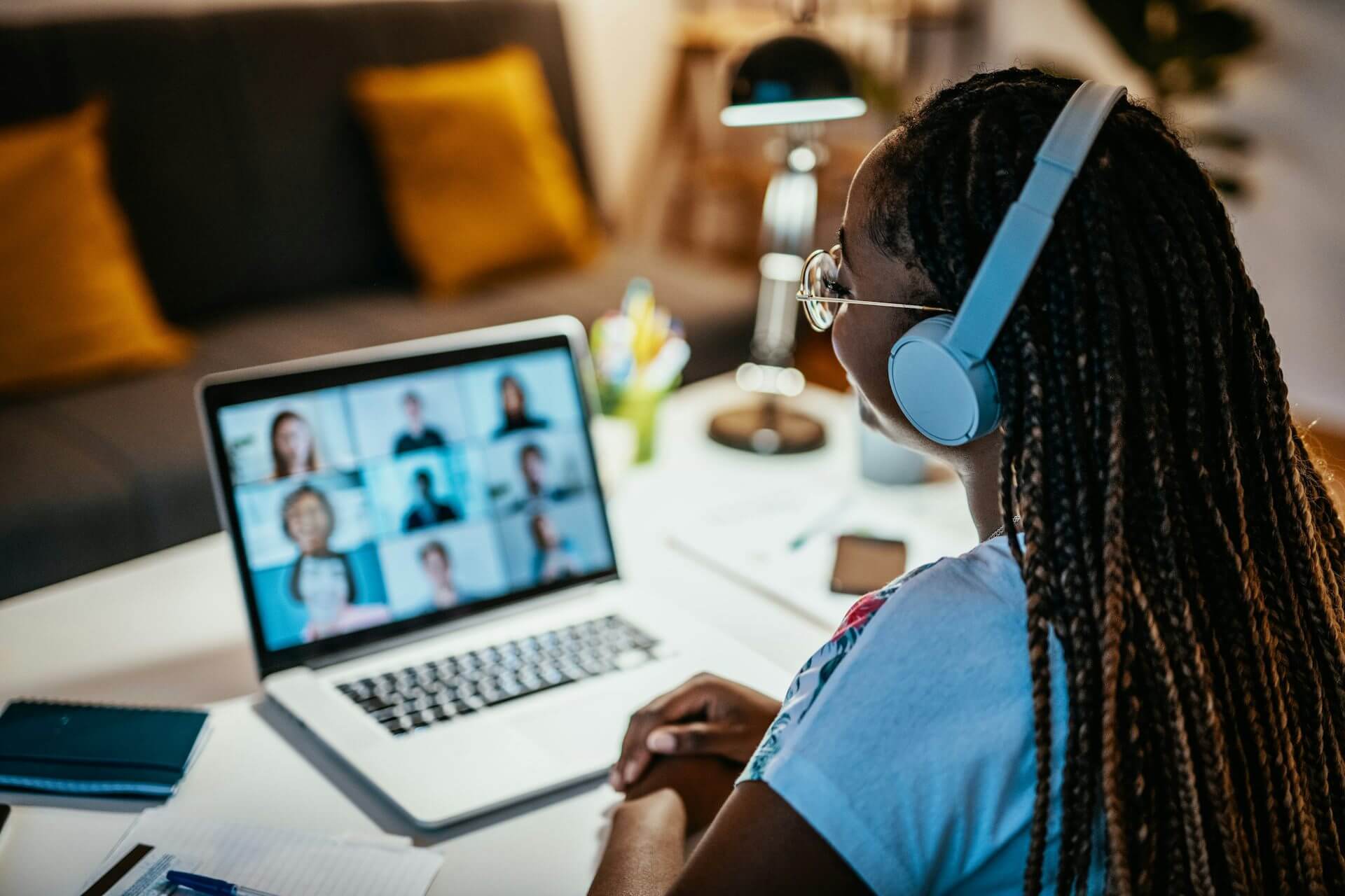 Young person wearing headphones looking at a computer screen hosting a Zoom call.